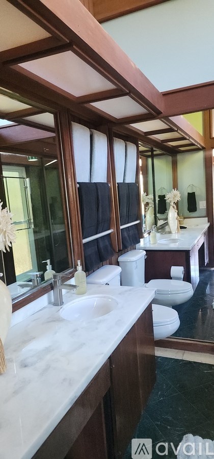A bathroom with a marble countertop and a large mirror.