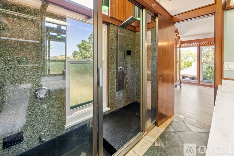A bathroom with a glass shower door and a wooden door.
