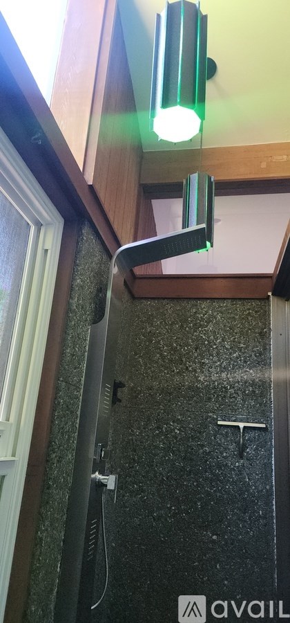 A bathroom with a shower and a green light.