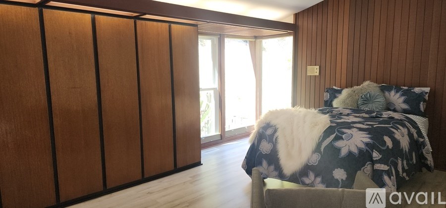 A bedroom with a bed and a wooden wall.