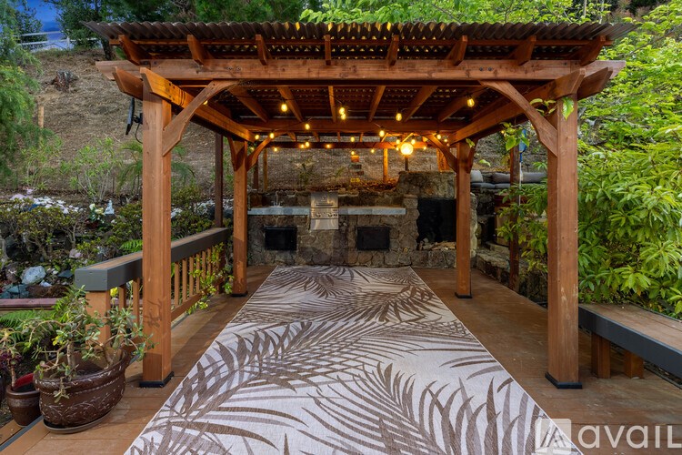 A wooden gazebo with a zebra print rug in the center.