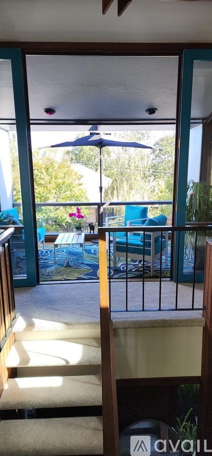A patio with a table and chairs and an umbrella.