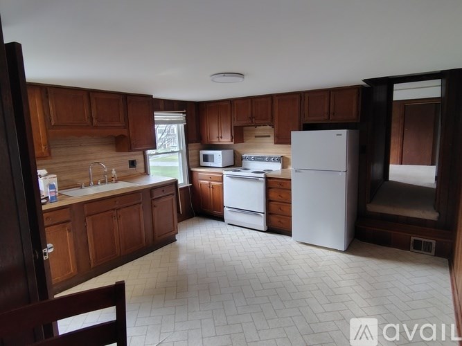 A kitchen with wooden cabinets and white appliances.