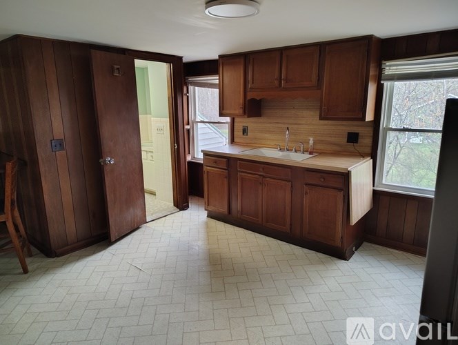 A kitchen with wooden cabinets and a white sink.
