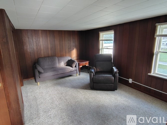 A living room with a grey couch and a black chair.