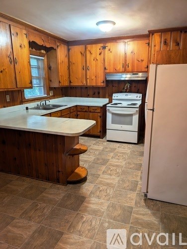 A kitchen with wooden cabinets and a white countertop.