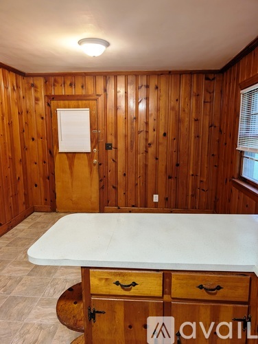 A wooden room with a white table and drawers.