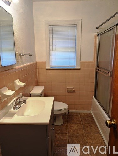A bathroom with a toilet, sink, and tub.