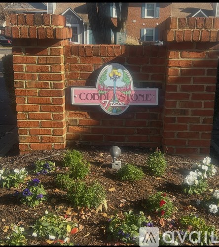 A sign that says Coddis Stone is mounted on a brick wall.
