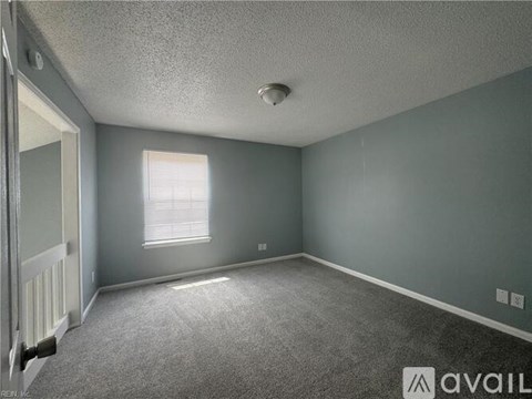A room with grey walls and a window with blinds.
