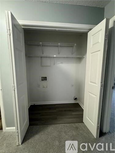 A white closet with a white door and a white wall.