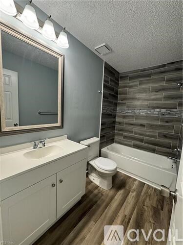 A bathroom with a white sink, toilet, and bathtub.