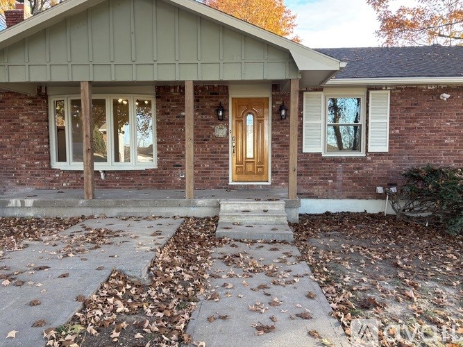 A house with a brown door and white windows.