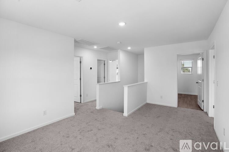 A spacious, empty room with a carpeted floor and white walls.