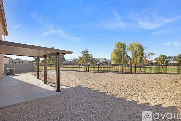 A backyard with a fence and a house in the background.