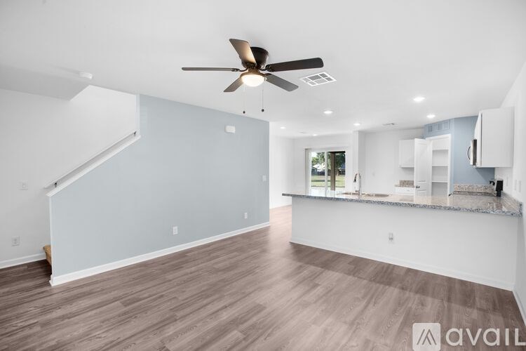 A spacious room with a ceiling fan and lighting fixtures.