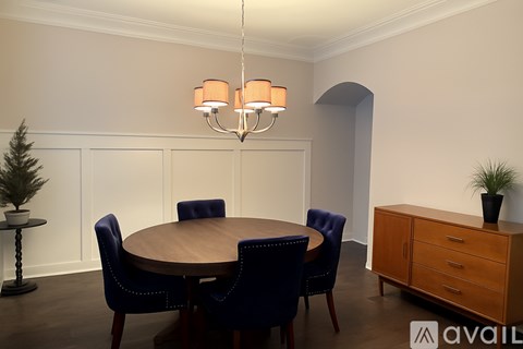 A dining room with a round table and chairs.