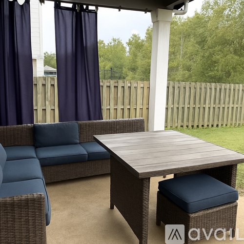 A patio with a couch, table and chairs.