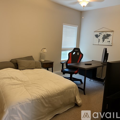 A bedroom with a bed, desk, and chair.