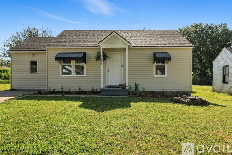 A small house with a front porch and two windows.