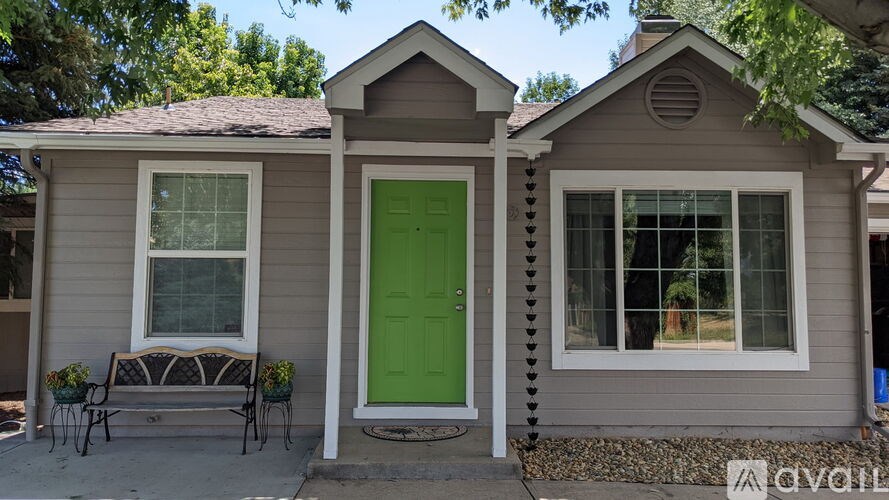 A house with a green door and a bench outside.