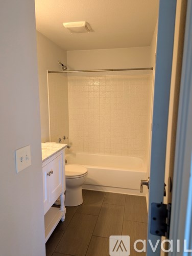 A white toilet sits next to a bathtub in a bathroom.