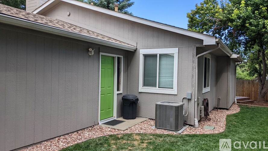 A house with a green door and a grey siding.