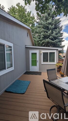 A small house with a deck and a table.