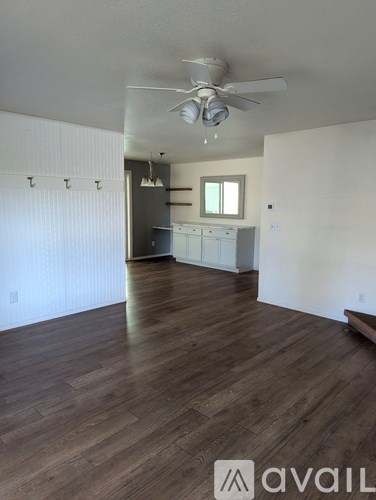 A room with wooden floors and a ceiling fan.