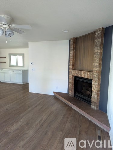 A room with a fireplace and wooden floors.