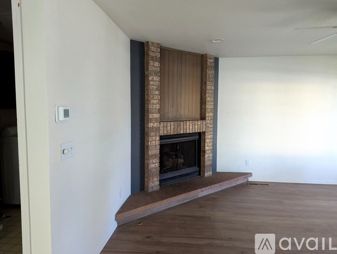 A room with a fireplace and wooden flooring.