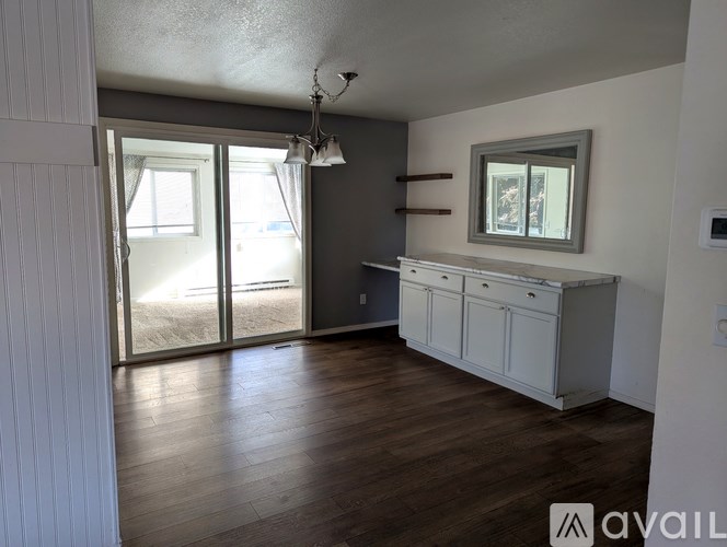 A room with a desk and a window with blinds.