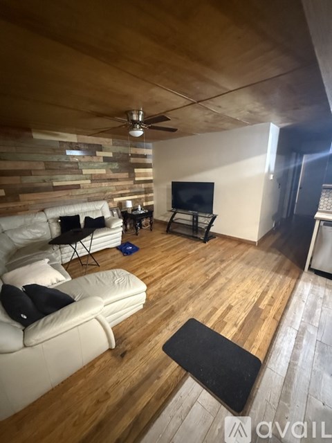 A living room with a white couch and a wooden floor.