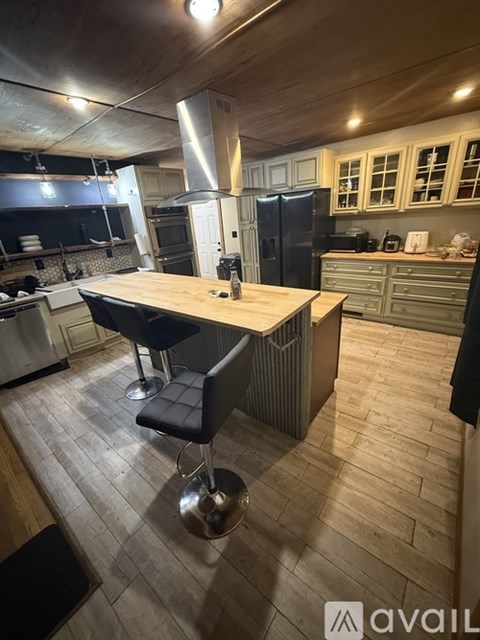 A kitchen with a wooden table and black barstools.