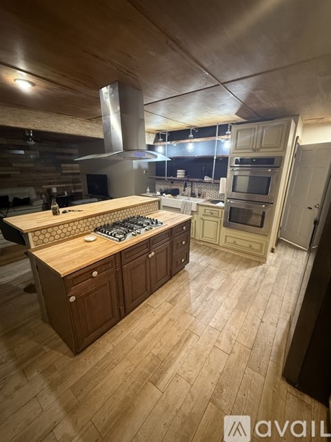 A modern kitchen with wooden cabinets and a large island.