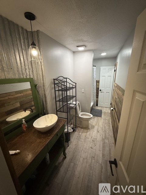 A bathroom with a green vanity and a white toilet.