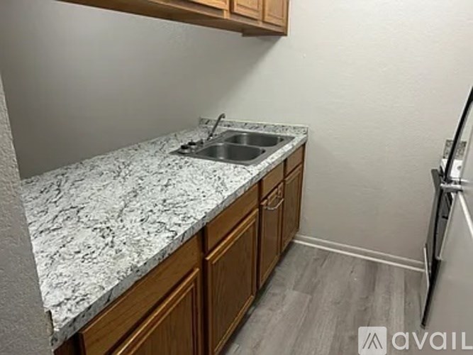 A kitchen with a granite countertop and wooden cabinets.