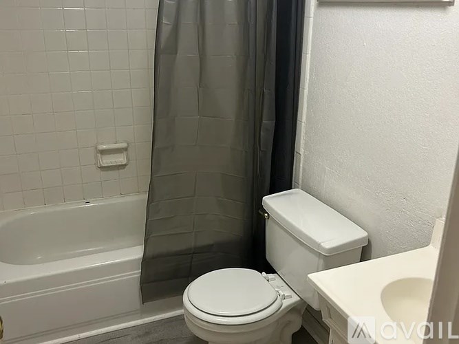 A white toilet sits next to a white sink in a bathroom.