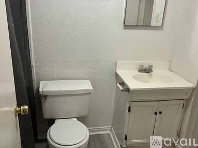A white toilet and sink in a small bathroom.