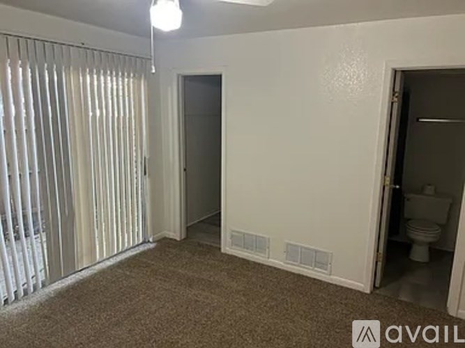 A room with a carpeted floor, a toilet, and a sink.