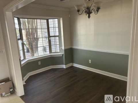 A room with a window and a chandelier.