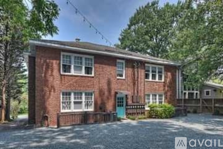 A red brick house with a green door and windows.