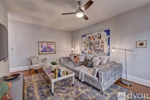 A living room with a grey sofa and a white coffee table.