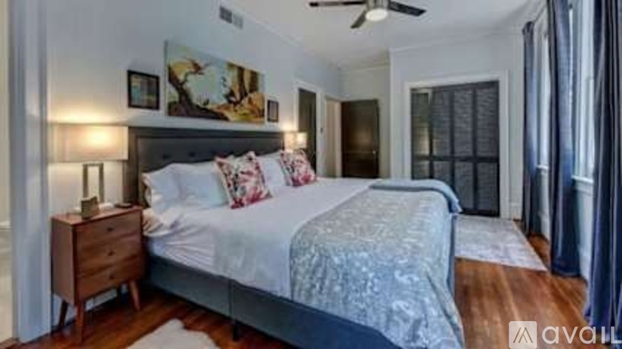 A bedroom with a large bed and a ceiling fan.