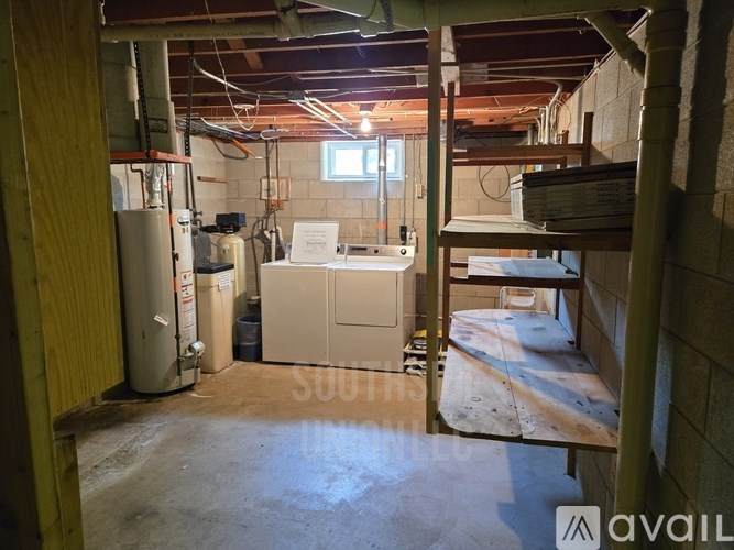 A room under construction with a refrigerator and a sink.