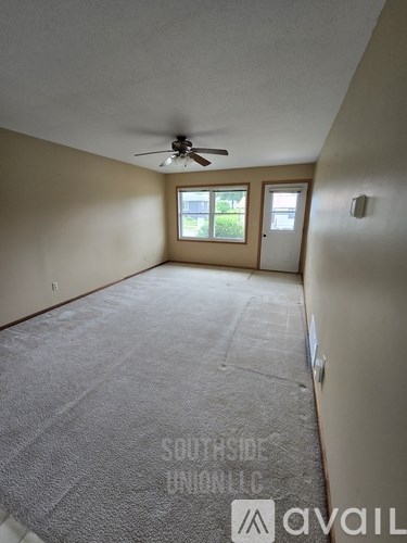 A room with a ceiling fan and a carpeted floor.