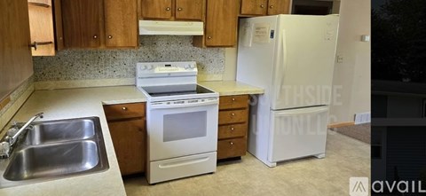 A kitchen with a white fridge, stove, and sink.