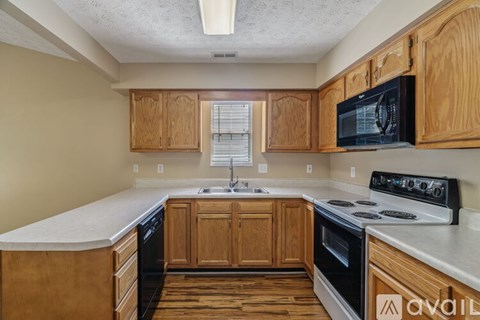 A kitchen with wooden cabinets and a black stove top oven.