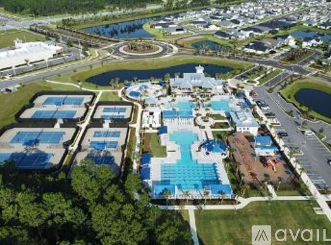 An aerial view of a resort with a large swimming pool and a water slide.