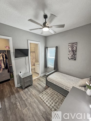A bedroom with a bed, dresser, and a ceiling fan.